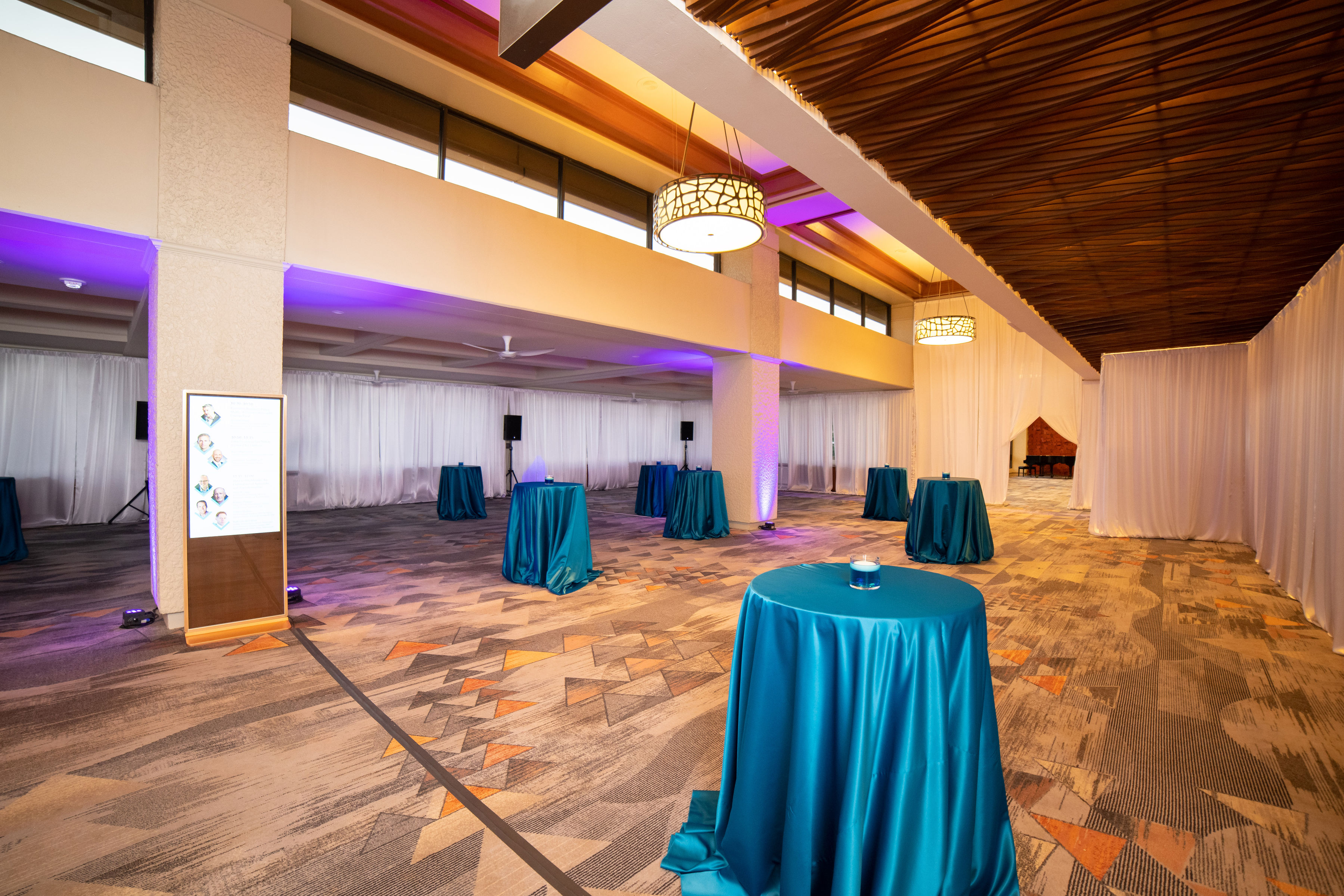 Conference reception lounge with teal linens and uplighting, run by Savvy Coordination