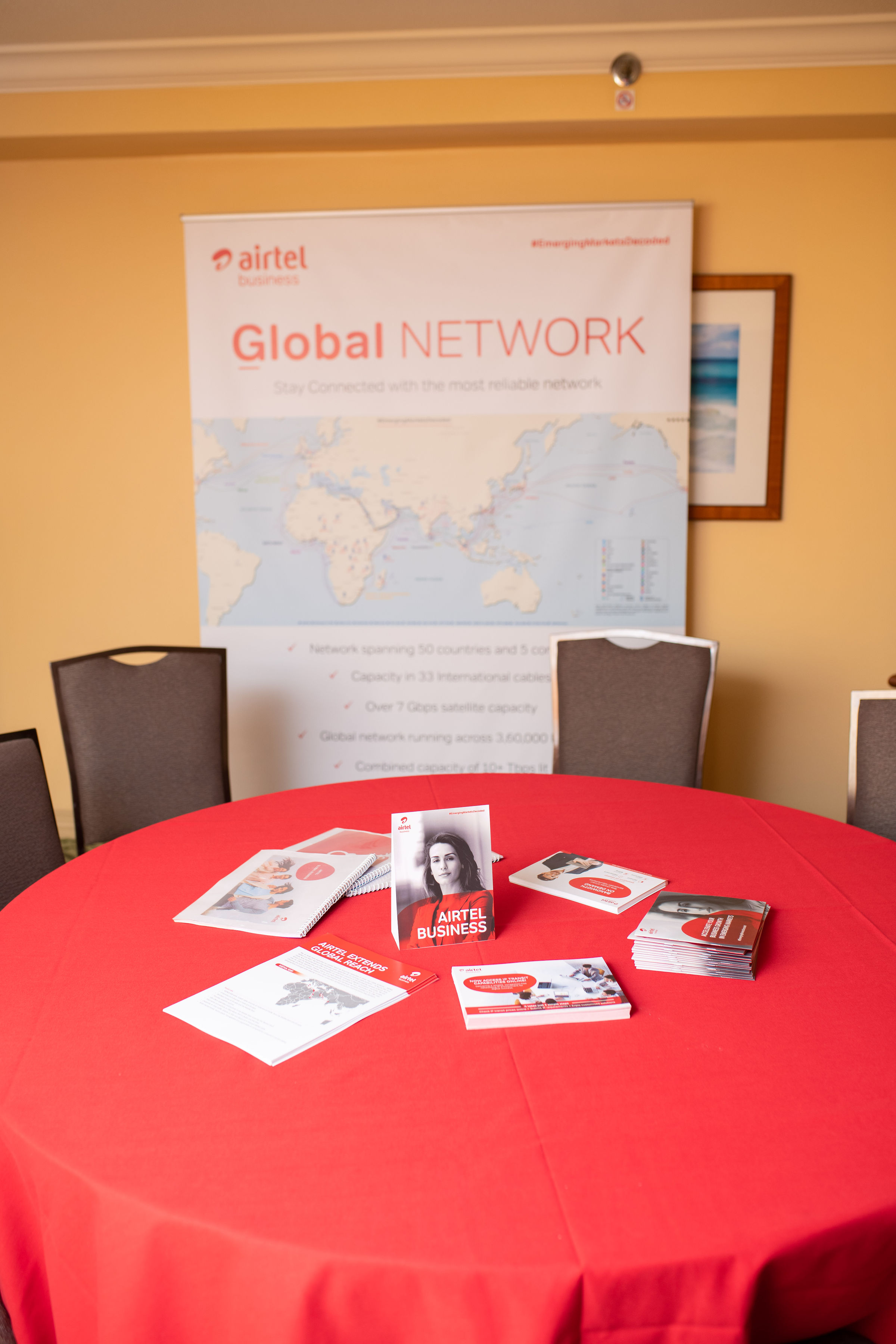 PTC conference sponsor tabletop display with marketing materials on a red-draped table